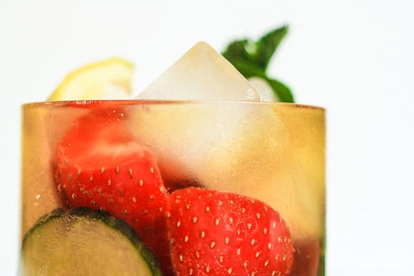 A glass of Homemade Pimms filled with fruit and ice