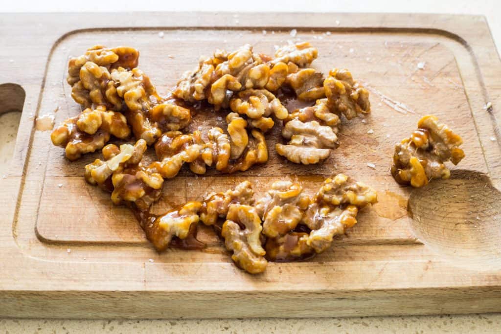 caramelised walnuts cooling on a wooden board