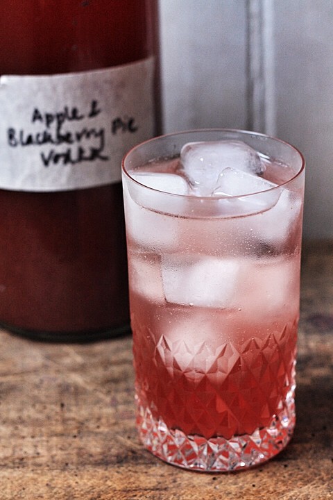 A close up of a glass of blackberry vodka on a table