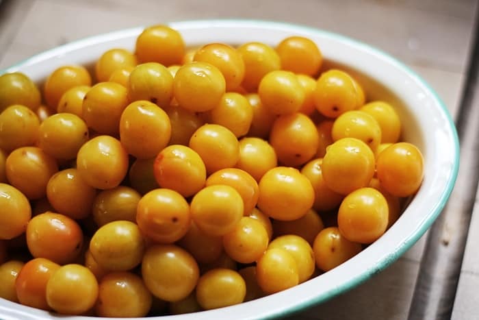 A bowl full of mirabelles on a table