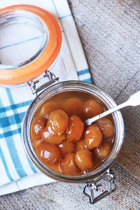 A jar of pickled mirabelles on a table