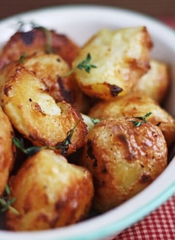 A close up of a bowl of roast potatoes
