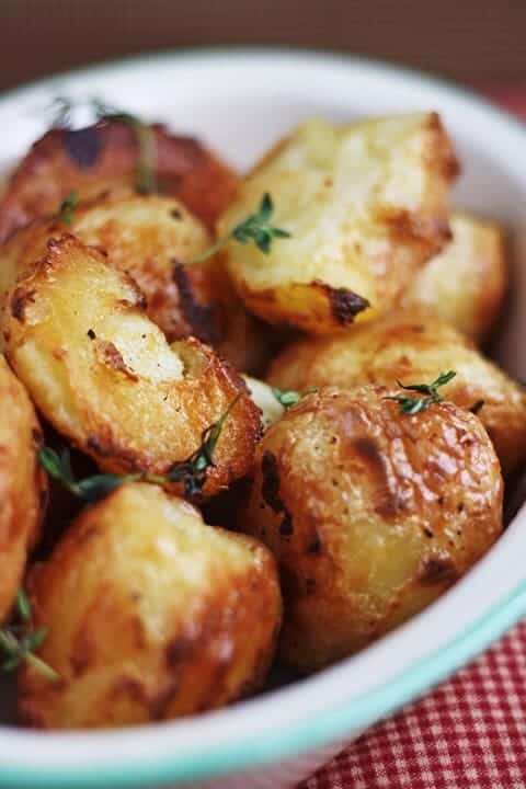 A close up of a bowl of roast potatoes 