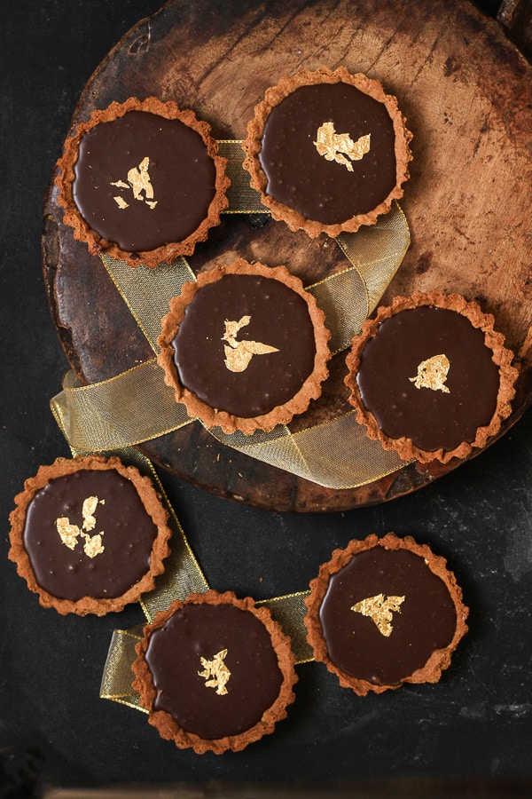 chocolate gingerbread tarts on wooden board with ribbon