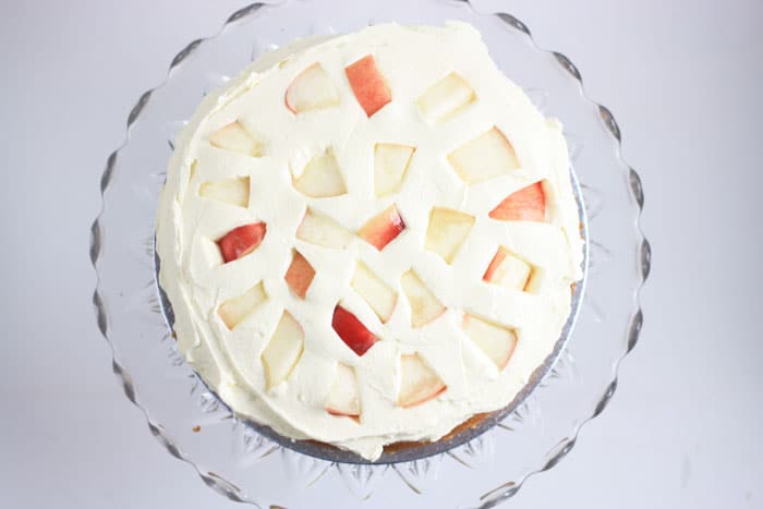cake with cream and nectarines on a stand