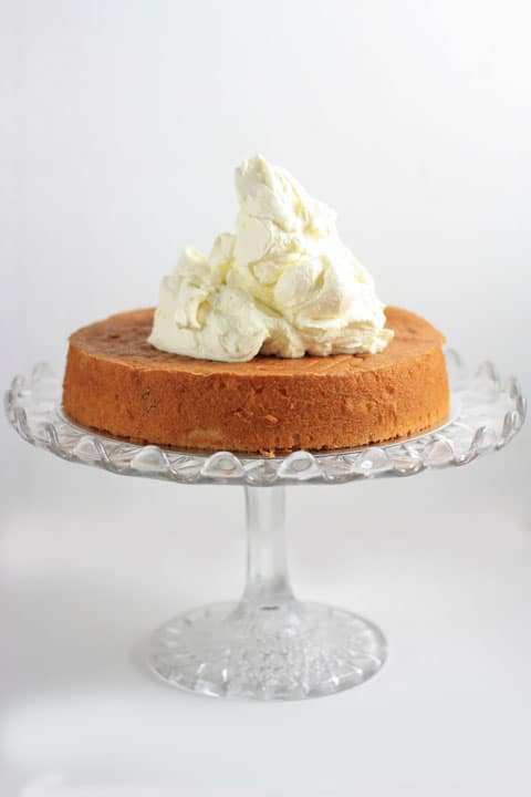 A of cake on a stand with cream billowing on top