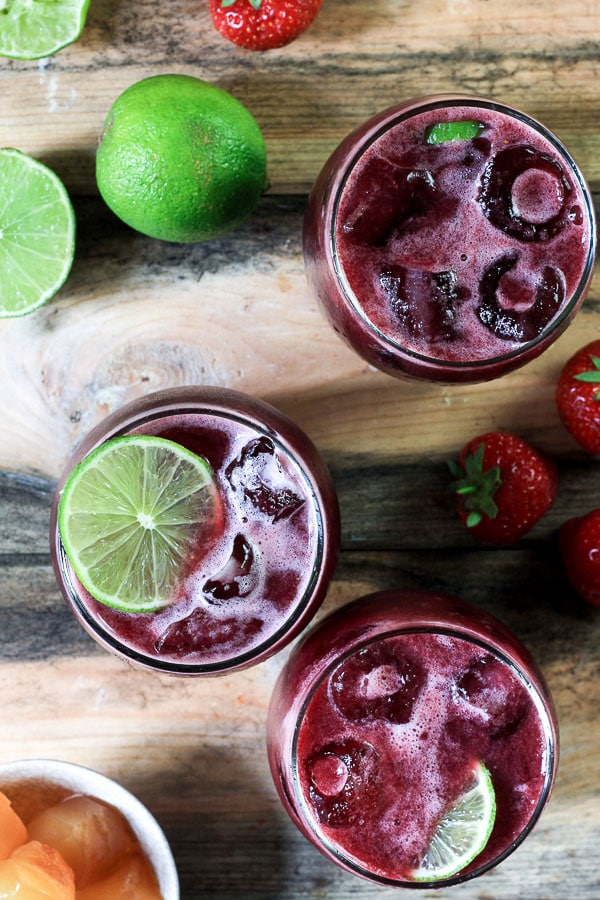 glasses of sangria on a table with limes