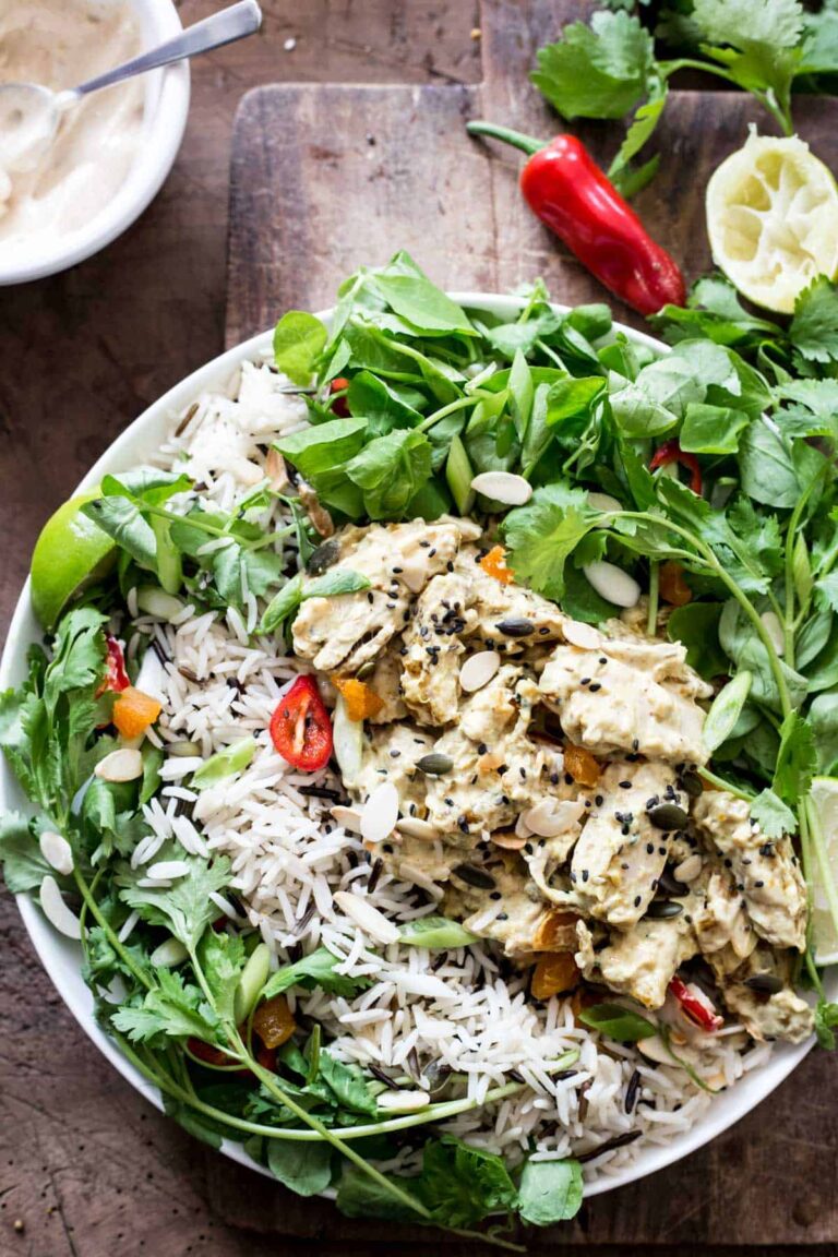 A bowl of Coronation Chicken Salad on a wooden board