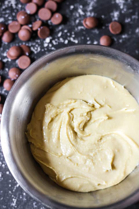 A bowl of cashew butter next to chocolate chips