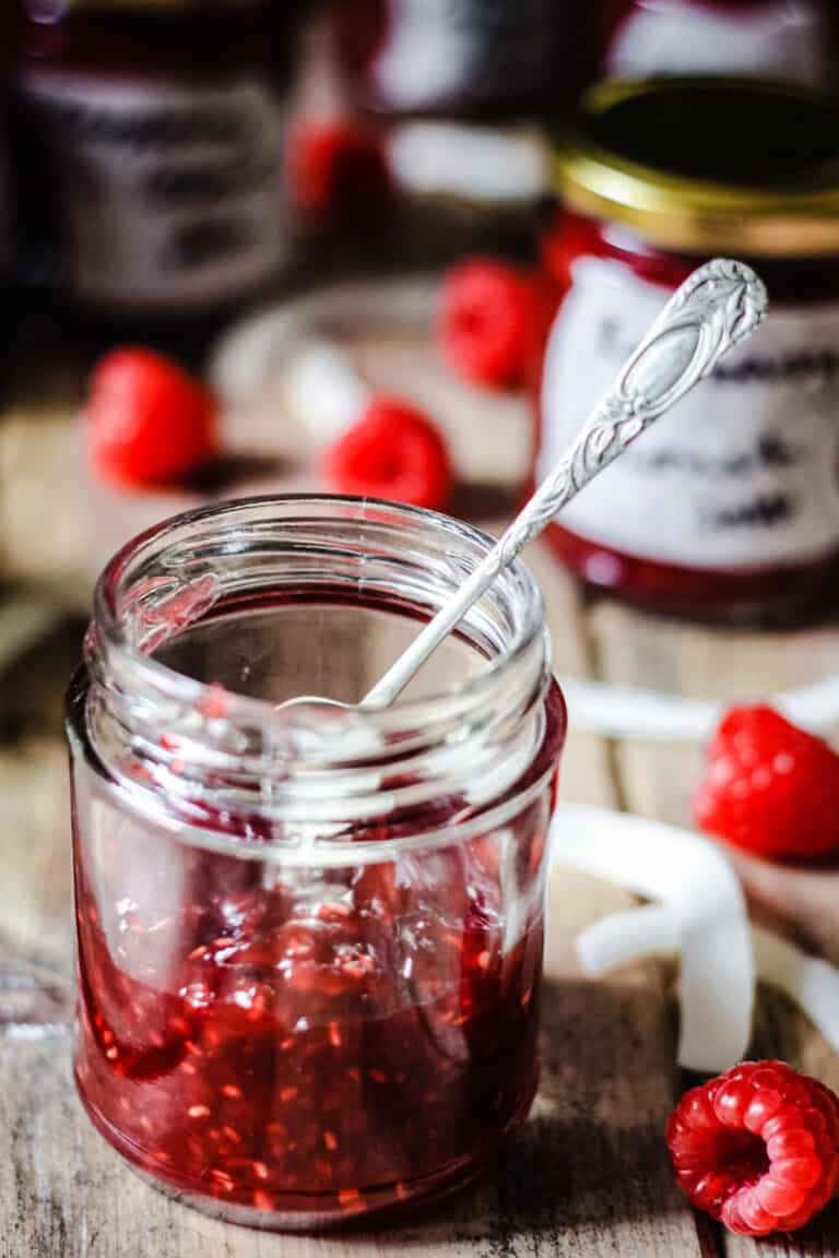 A jar of Raspberry Coconut Jam with a spoon