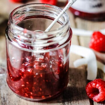A jar of Raspberry Coconut Jam with a spoon