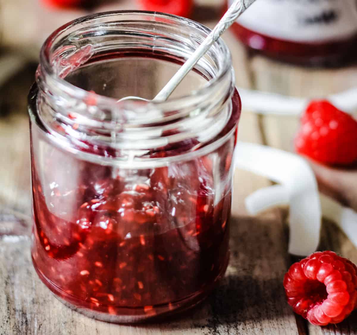 A jar of Raspberry Coconut Jam with a spoon