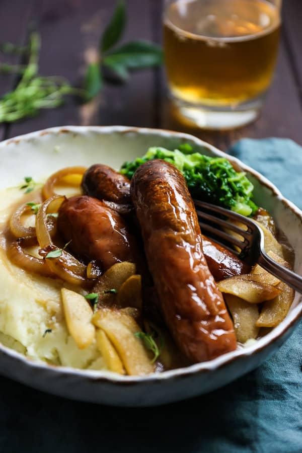 A plate of sausage and mash on a table