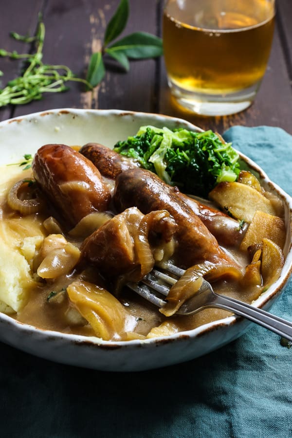 A bowl of sausage and mash on a table