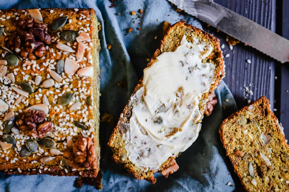 Sliced loaf of Happiness bread with butter slathered over one slice.