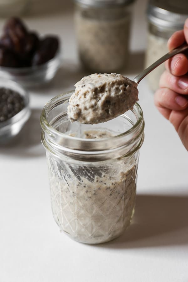 hand lifting out a spoonful of chia pudding from a jar