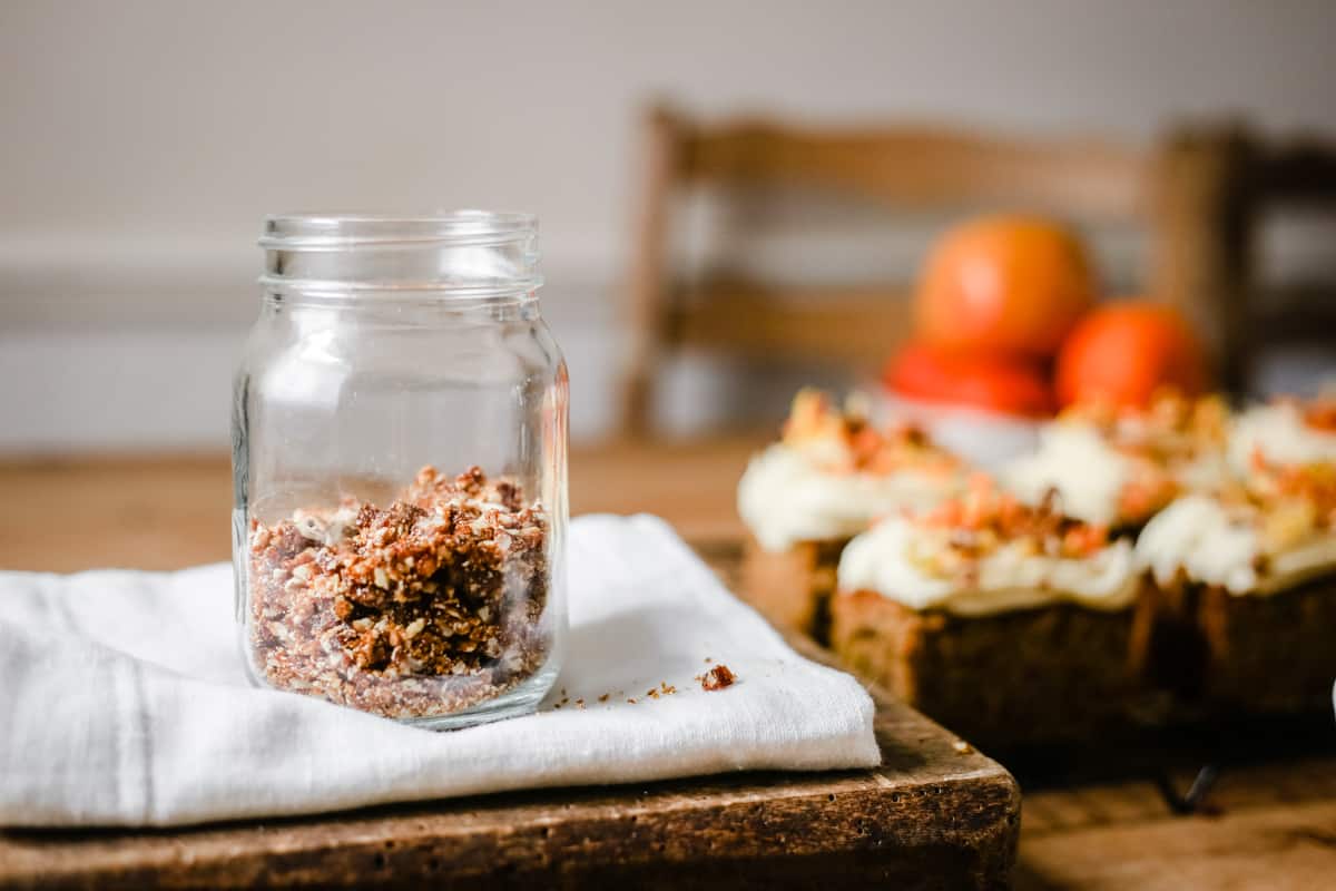 pecans in a jar next to slices of cake