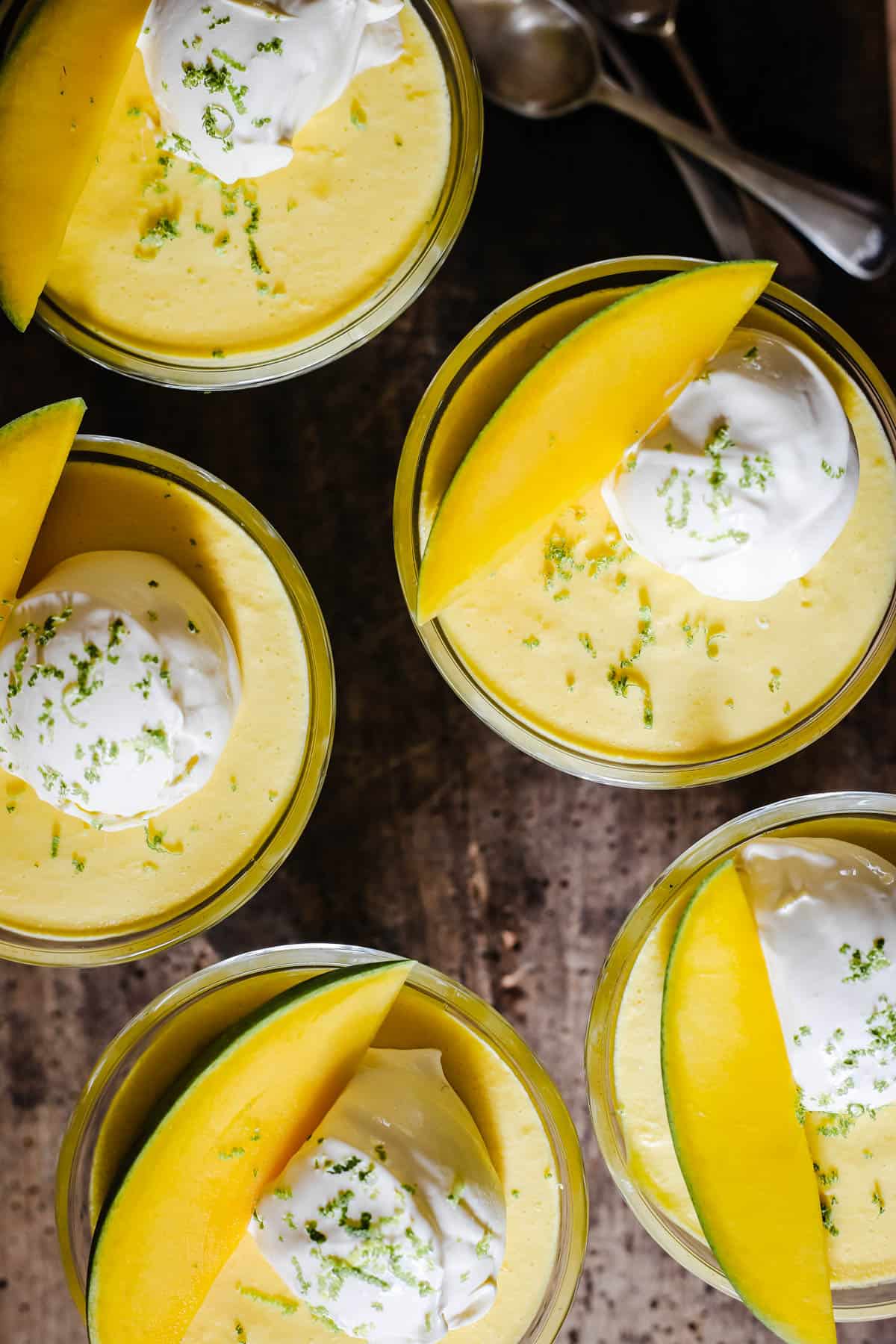glass bowls of mango pudding on a wooden table