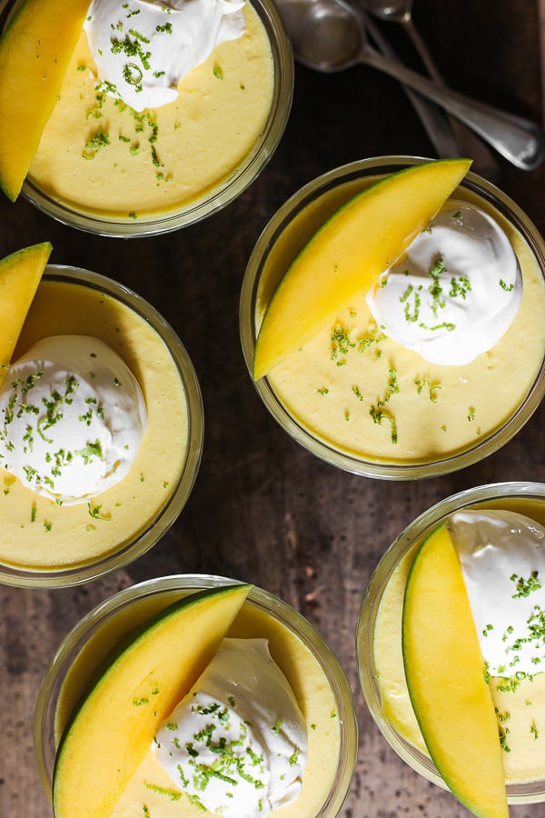 glass bowls of mango pudding on a wooden table