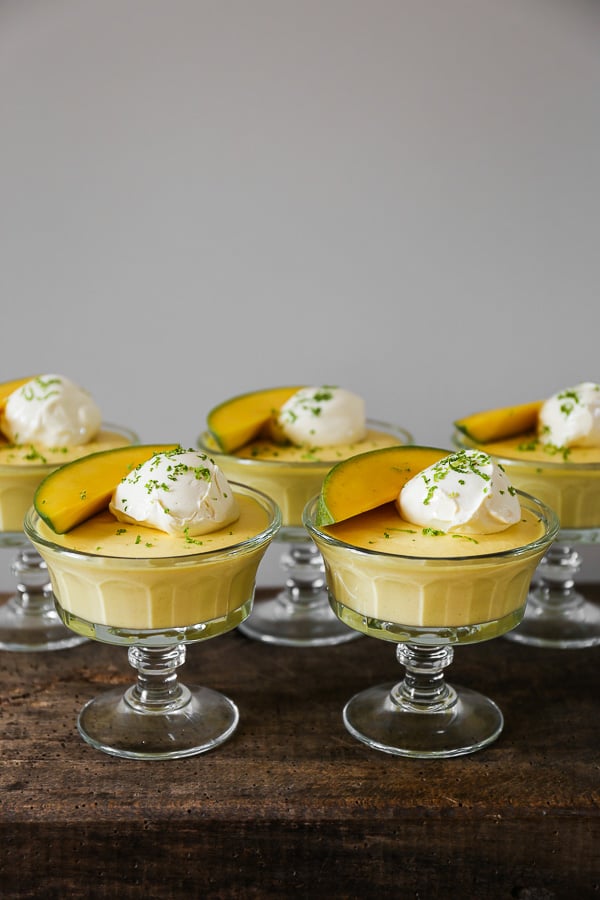 glass bowls of mango pudding on a wooden table