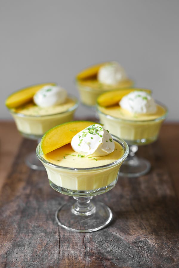 glass bowls of mango pudding on a wooden table