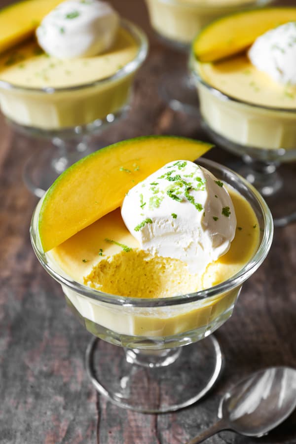 A bowl of mango pudding with spoon ful taken out