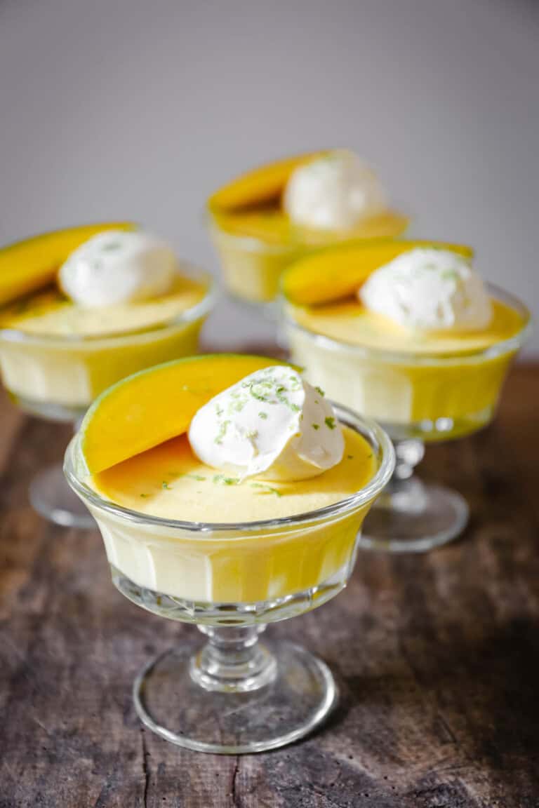 glass bowls of mango pudding on a wooden table