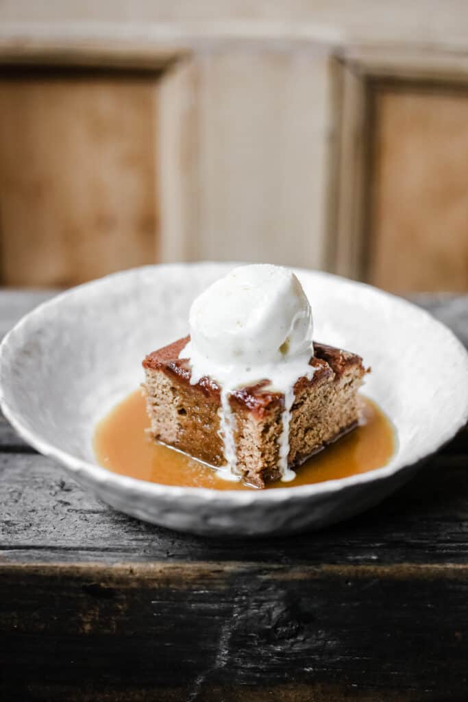 Sticky Toffee Pudding in a bowl with ice cream on top