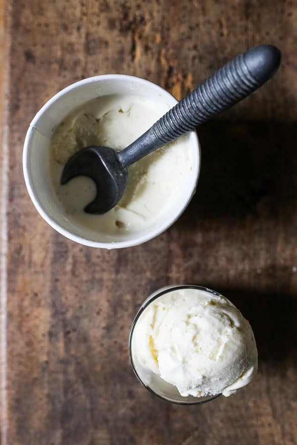 A bowl of ice cream with a spoon on wooden table