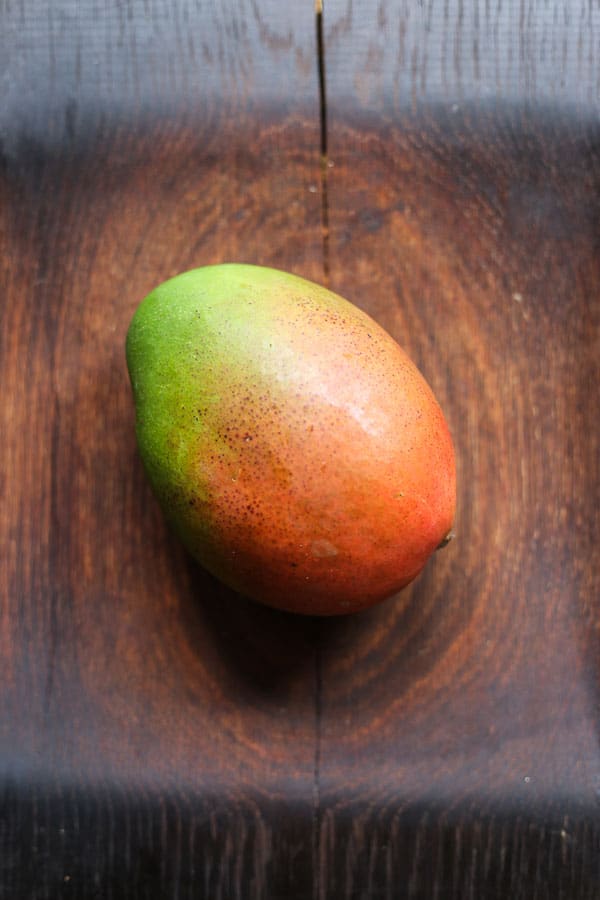 A mango sitting on top of a wooden table