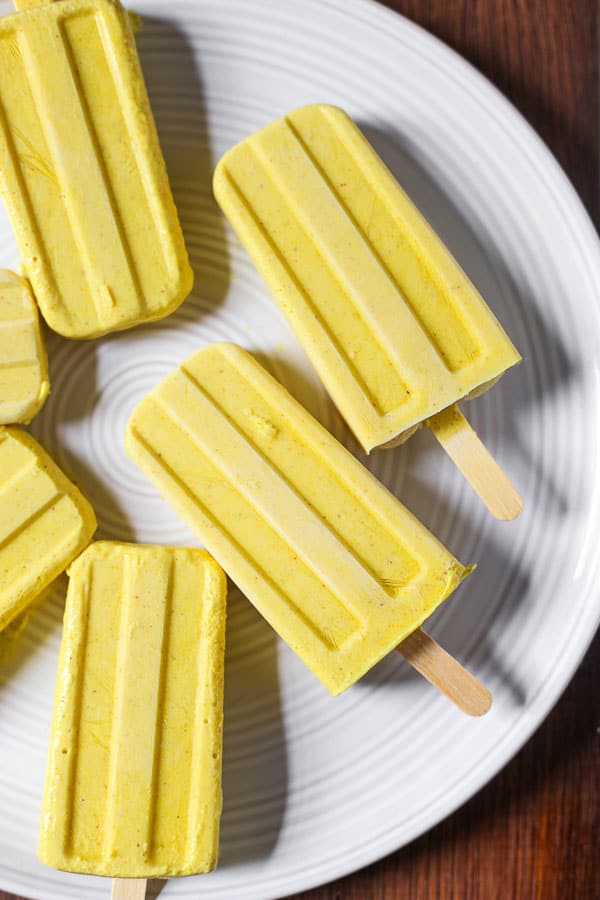 A plate of ice lollies on a wooden table