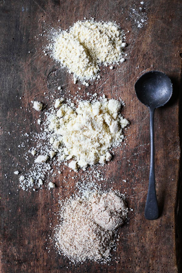 overhead shot of almond flour, ground almonds and almond meal on a wooden board with a spoon