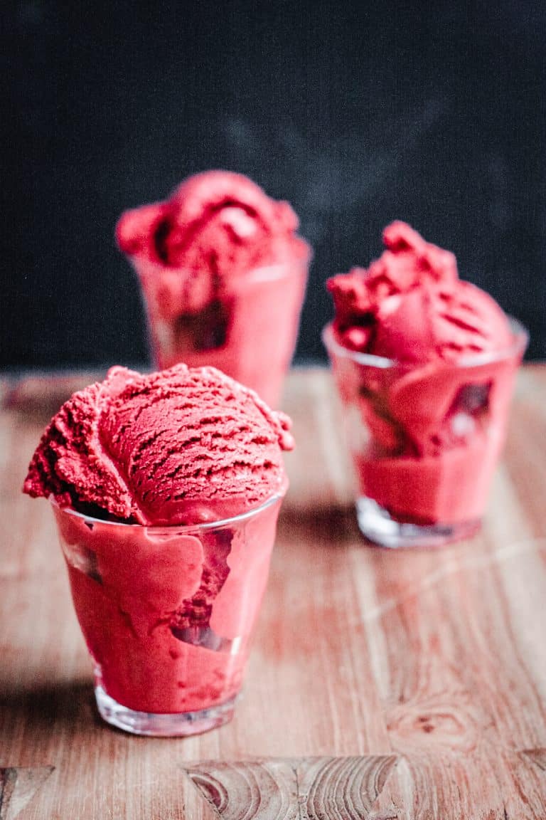 Glasses of red velvet ice cream on a wooden table
