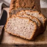 Gluten-Free Banana Bread sliced on a wooden board.