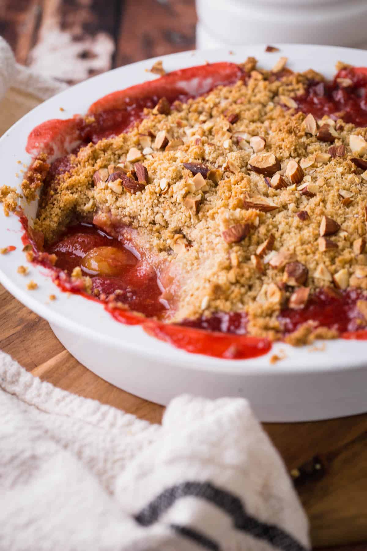 Straight on image of a dish of Strawberry Gooseberry Crumble with a spoon