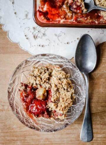 Overhead image of a bowl of Strawberry Gooseberry Crumble with a spoon
