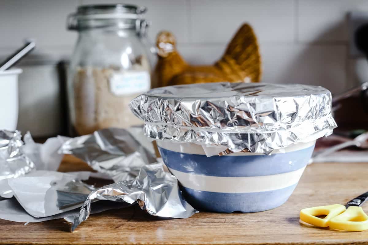 chocolate pudding in a pudding bowl covered with foil and tied with string ready to be steamed