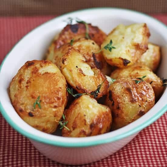 A bowl of roast potatoes on table