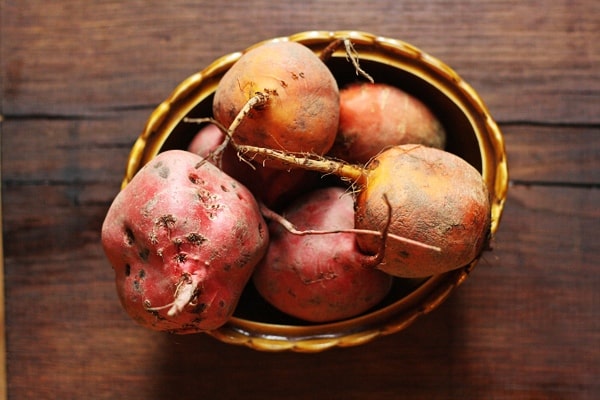 A bowl of beetroot sitting on top of a wooden table