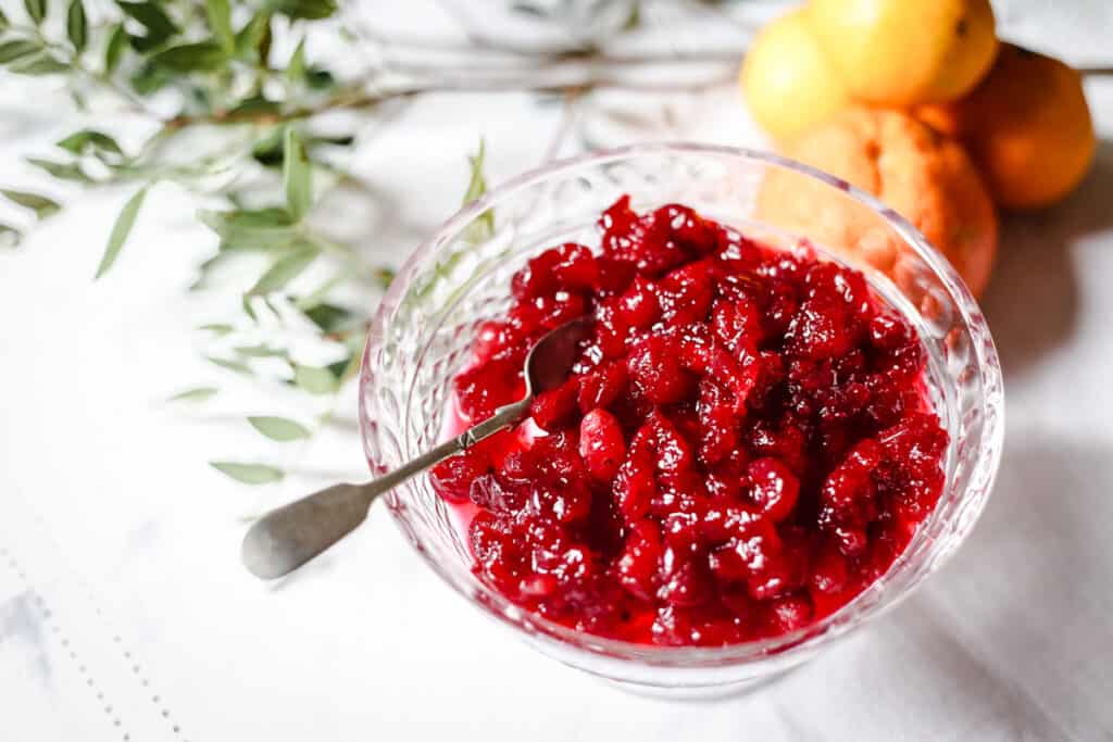 Cranberry Clementine Sauce in a glass bowl on a white tablecloth