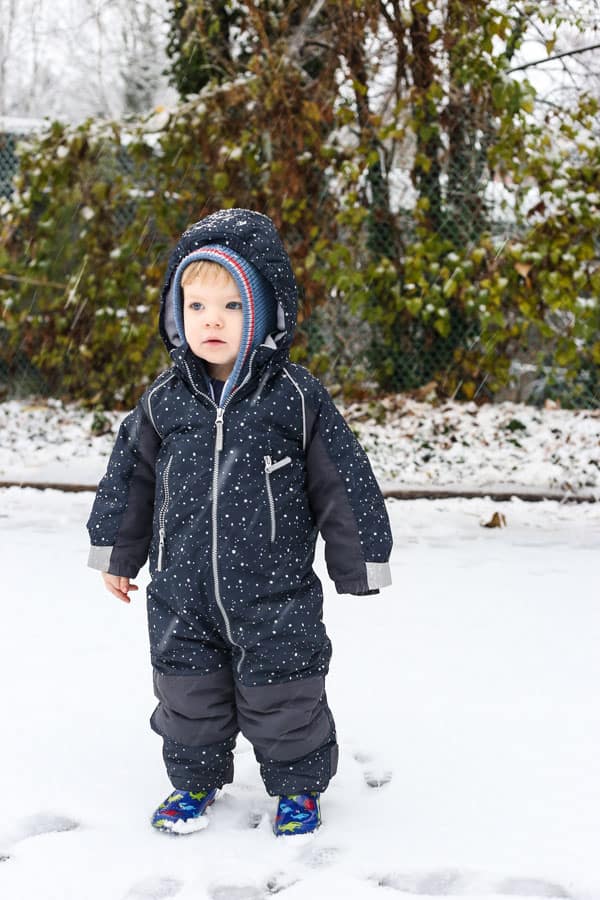 A little boy that is standing in the snow