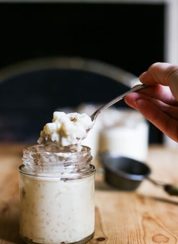 hand holding spoon lifting out rice pudding from a jar