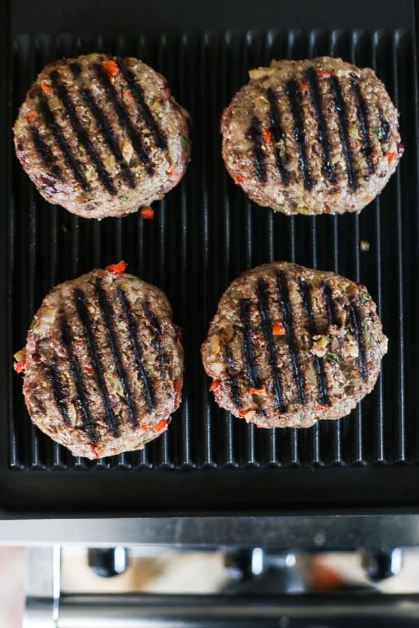 A close up of burgers on a grill