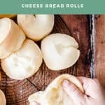 Pin image of cheese rolls on a wire rack and hand pulling one apart showing its cheesy inside. With Title text surrounding the image