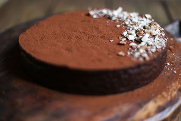 A close up of a chocolate torte on wooden board
