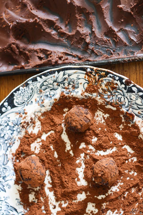 A piece of chocolate truffle rolled in cocoa powder on a plate