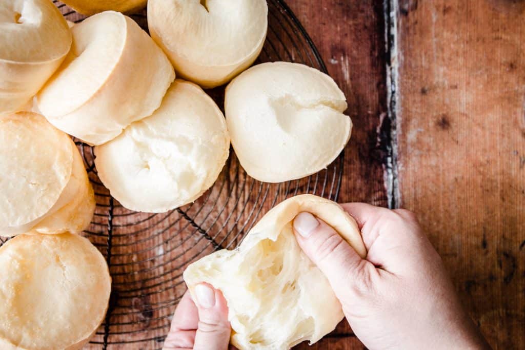 Cheese Rolls on a wire rack and one being pulled apart to show cheesy inside