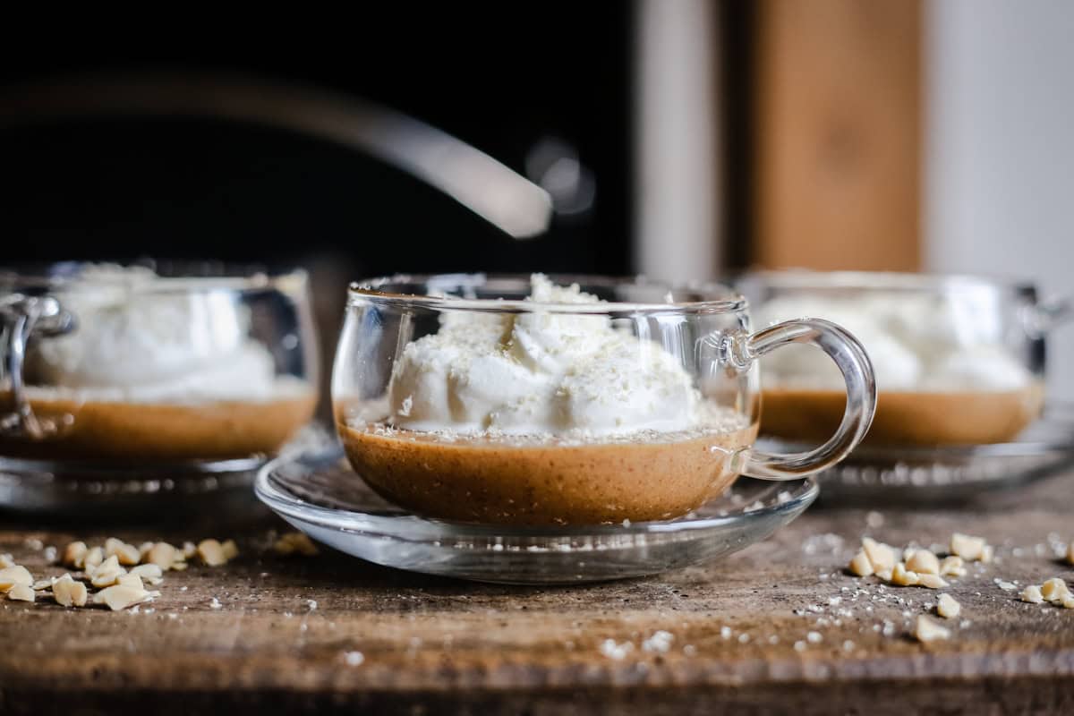 A cup of chocolate mousse and cream on a table