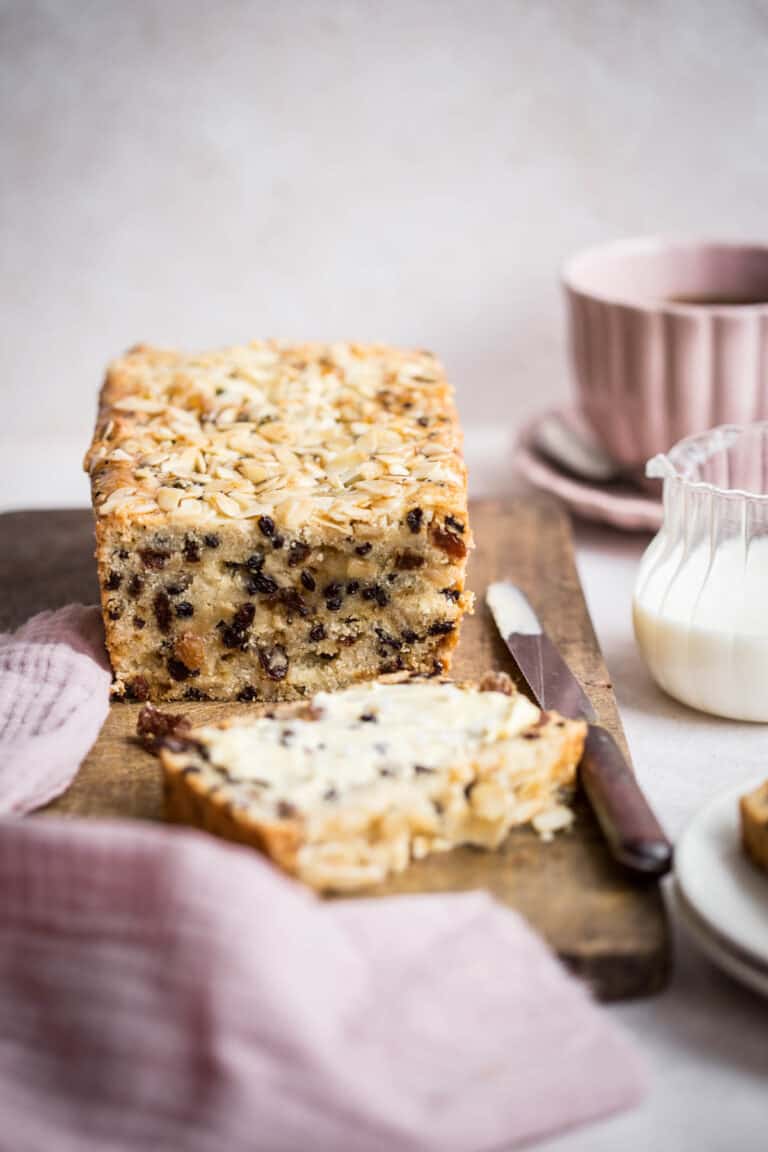 Vinegar Cake on a wooden board with a buttered slice in front
