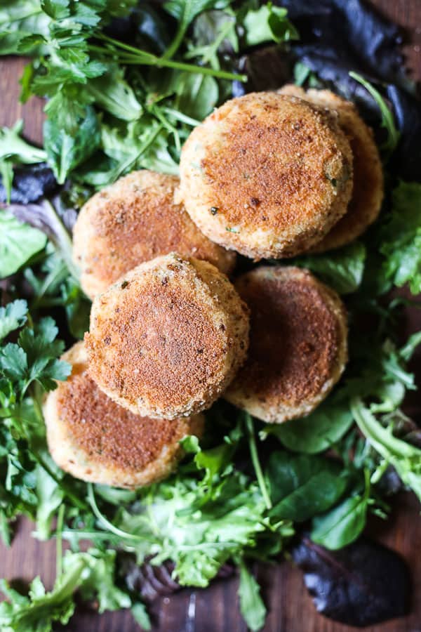 A close up of a plate of fishcakes with salad